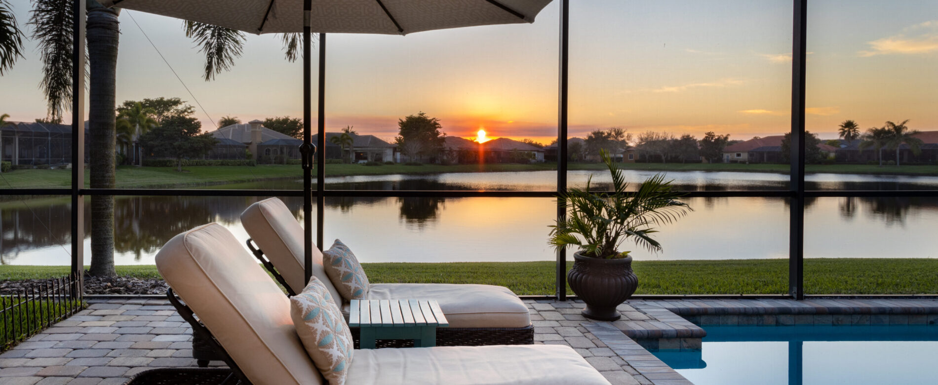 Florida screened swimming pool with lounge chairs overlooking la